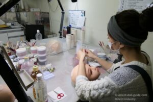 Orient Industry artisan handcrafting makeup on a Japanese love doll head during the production process